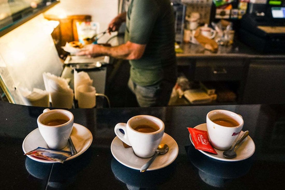 Three espresso cups on a café counter representing ristretto, espresso, and lungo