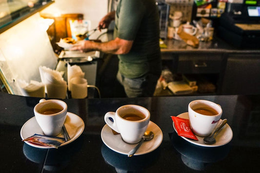 Three espresso cups on a café counter representing ristretto, espresso, and lungo