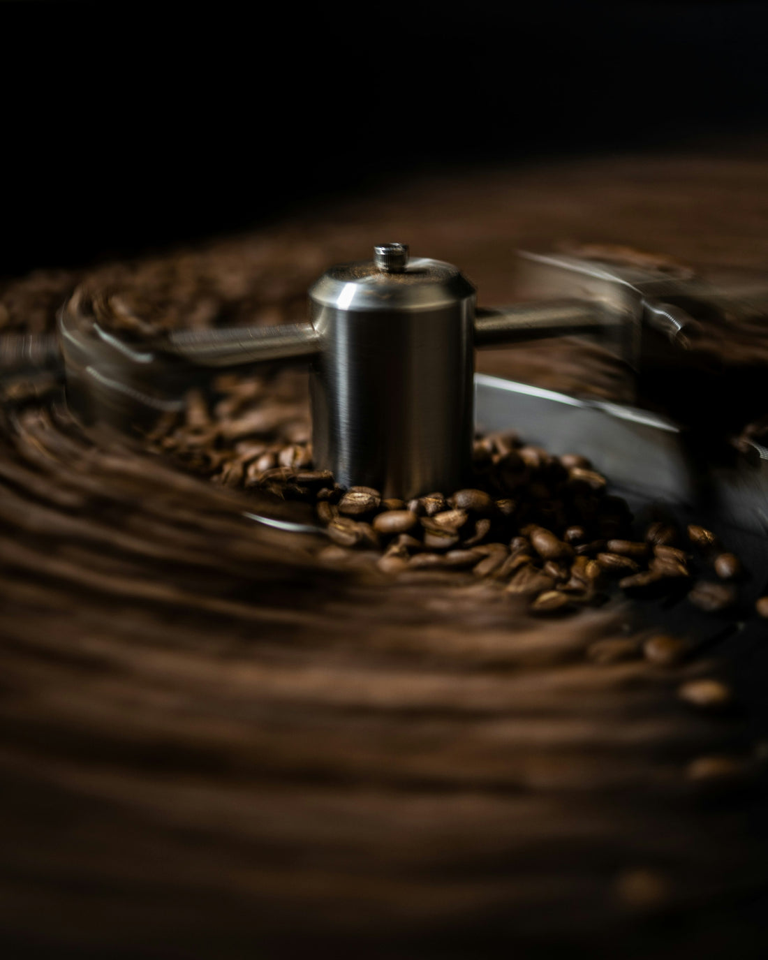 Freshly roasted coffee beans cooling in a metal roasting tray after a batch